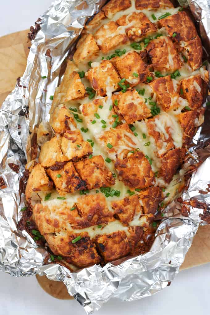 Cheesy Pesto Garlic Pull Apart Bread - A cheese filled treat. The perfect side dish for dinner or snacking. Pesto adds a depth of flavour to this pull apart bread with the mountains of melting mozzarella cheese.