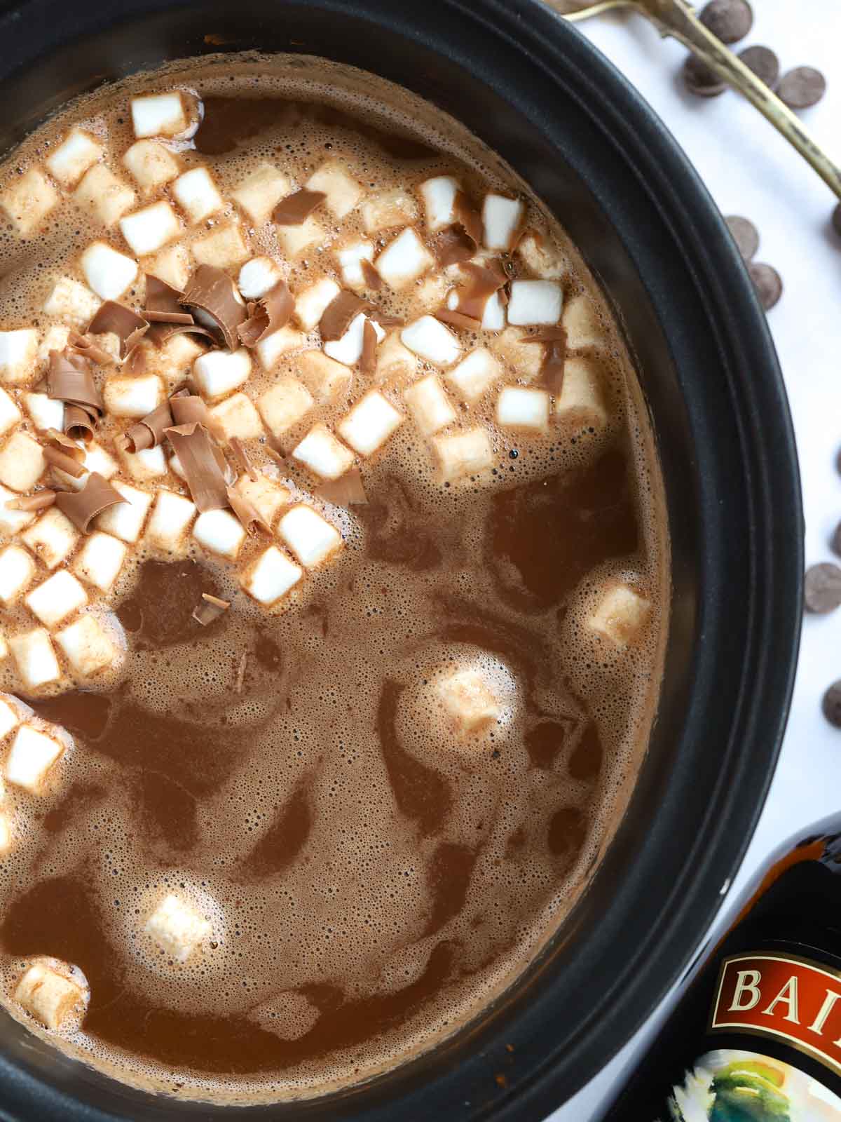 Baileys hot chocolate made in a slow cooker with cream and cocoa, with marshmallows on top.
