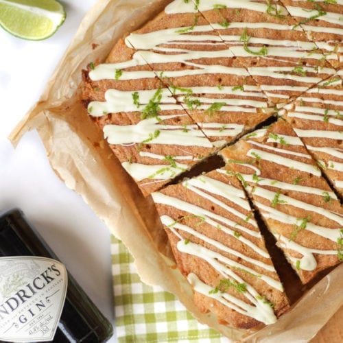 These Gin and Tonic Cake Bars are super simple and delicious. An easy cake packed with gin and tonic flavour, with zesty lime and a crunchy glaze. Based on a lemon drizzle cake style recipe, with gin infused syrup and topped with white chocolate. #ginandtonic #cakerecipe #easydessert #tamingtwins