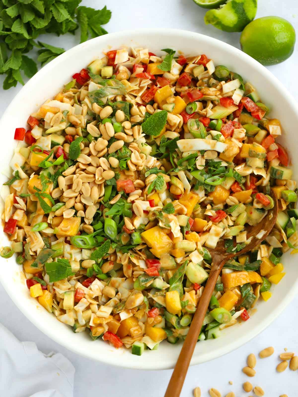 A big bowl of Cabbage salad with peanut butter dressing, peppers, cabbage and mango.