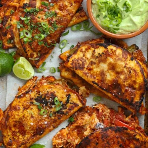 Fried tacos with chicken, with a creamy dip in a bowl to the side.