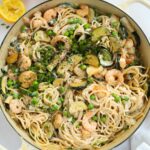 A big bowl fill of prawn pasta with courgettes, peas, prawns and spaghetti, ready to eat.
