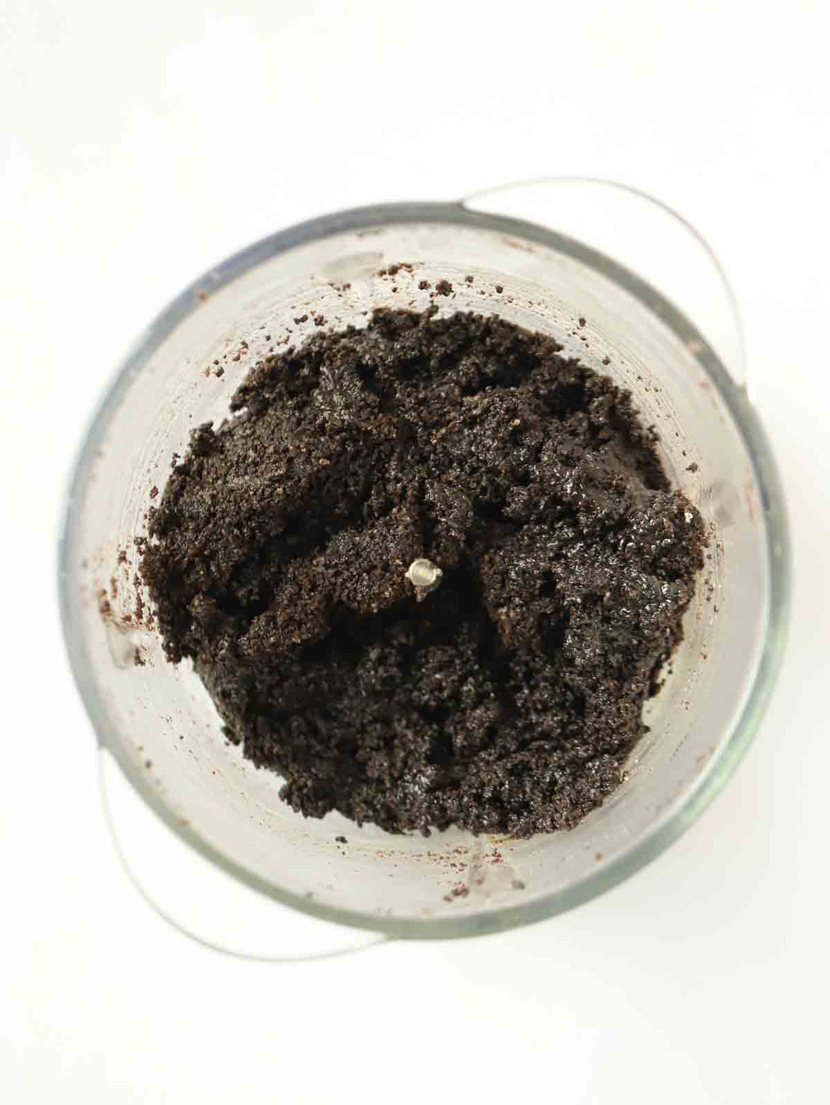 Oreo cookies crushed up in a processor for step 1 in the recipe for Oreo Cheesecake.