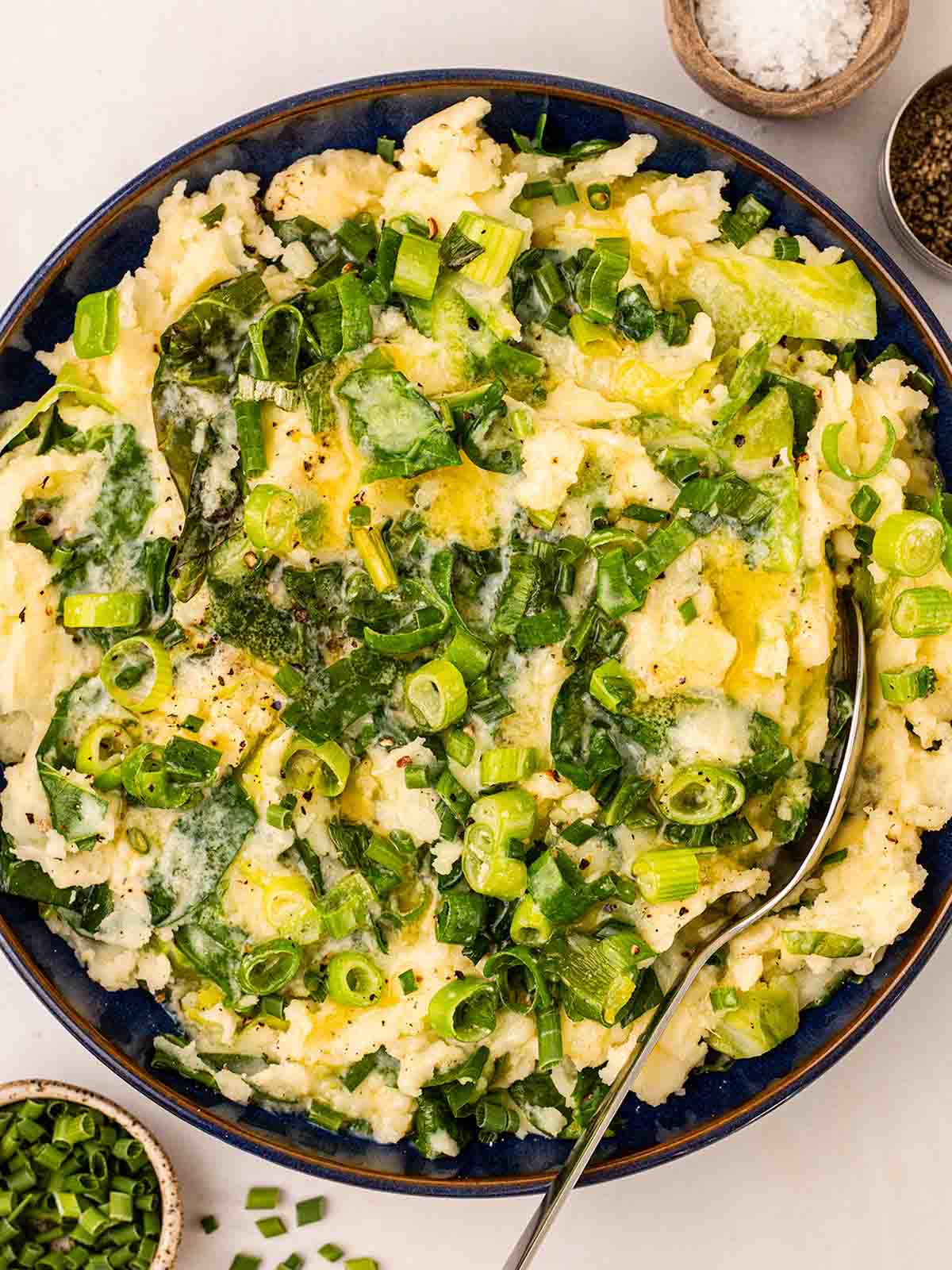 A bowl filled with creamy colcannon mashed potato with cabbage and spring onion.