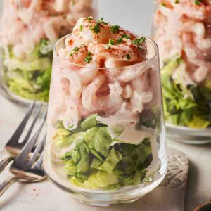 A close up of a classic Prawn Cocktail, with two more in the background, ready to eat.
