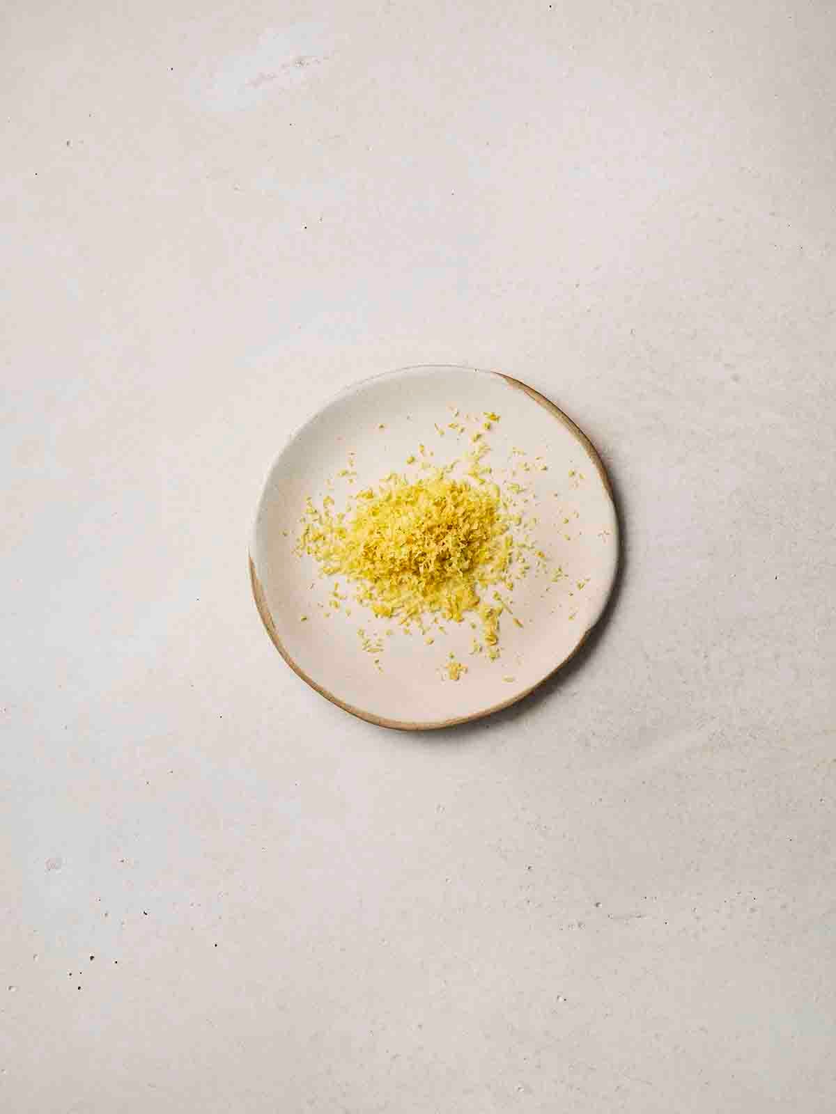 The zest of a lemon on a small white plate.