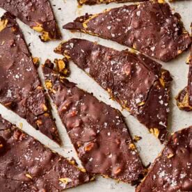 A close up of date bark with chocolate and peanut butter, with salt over the top, broken into pieces.