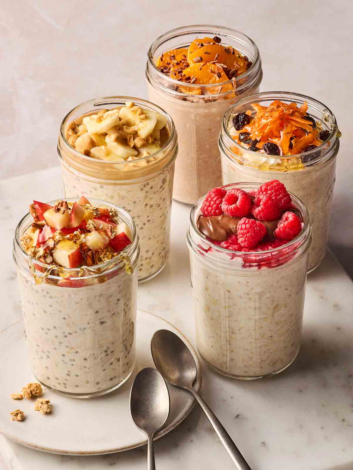 Far jars of overnight oats in jars with different toppings.