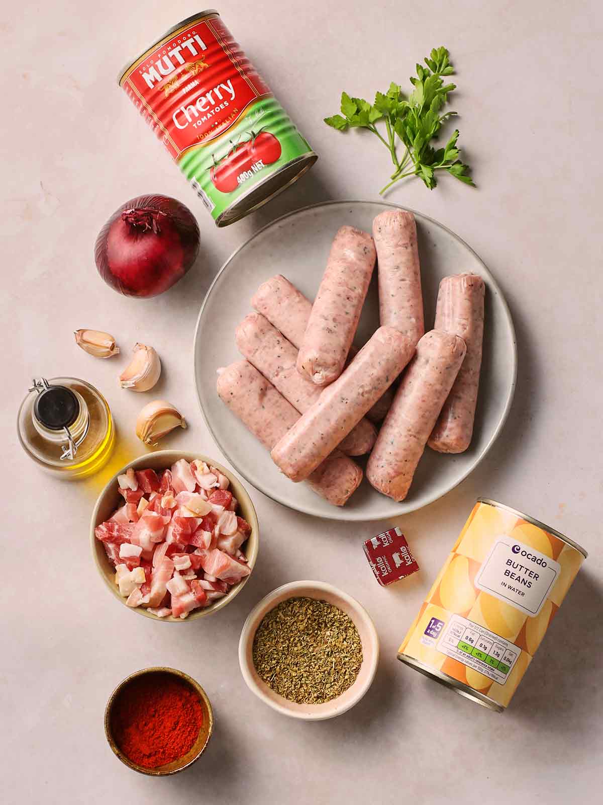 The raw ingredients for making sausage casserole laid out on a white counter.