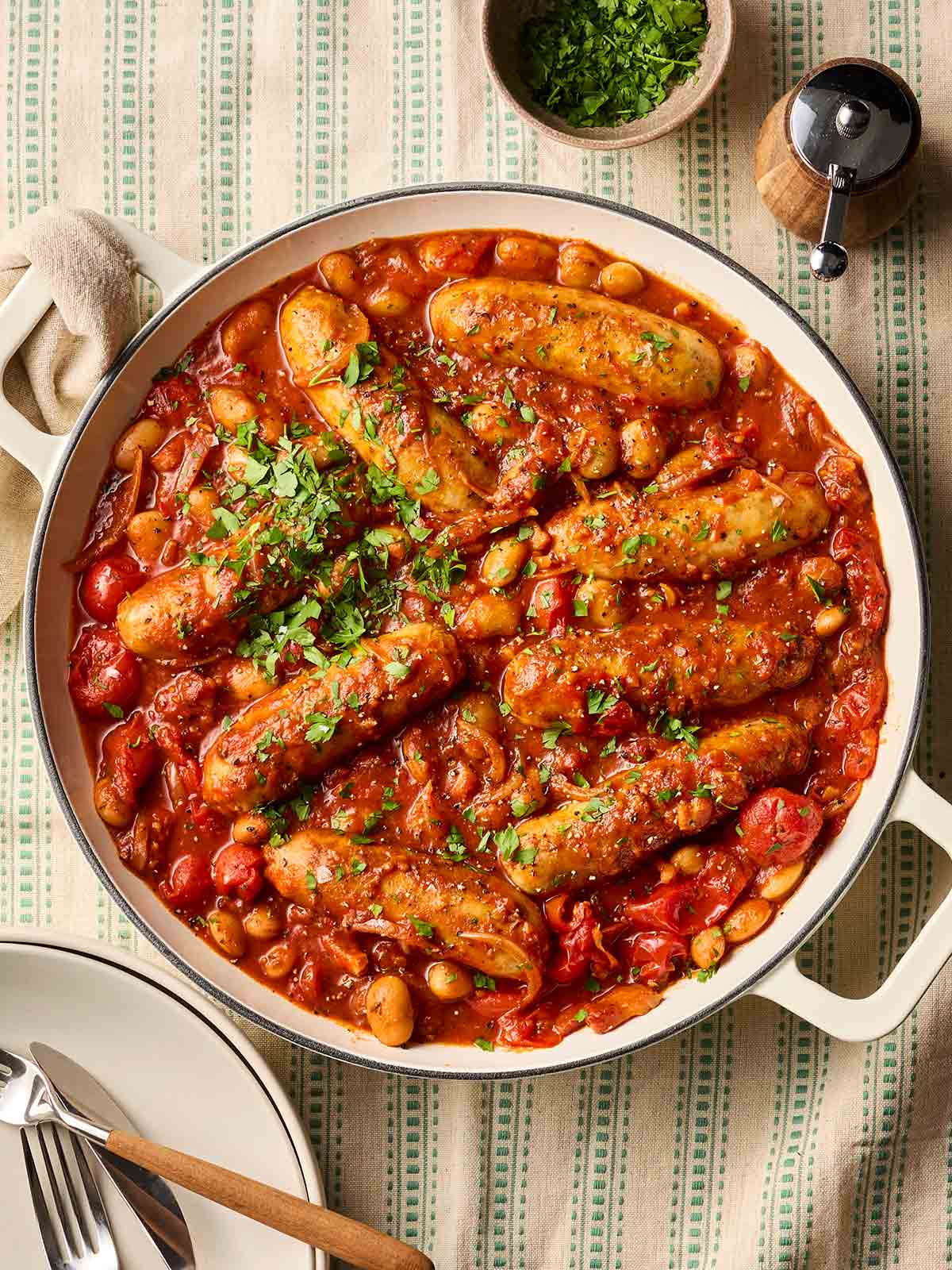 A large pan of sausage casserole ready to serve on a dining table.